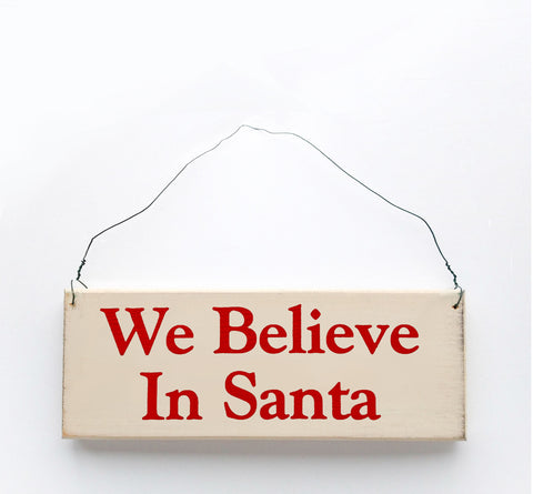 Wood sign saying: We Believe in Santa. Handmade from natural, ethically sourced wood in Pembroke, MA.